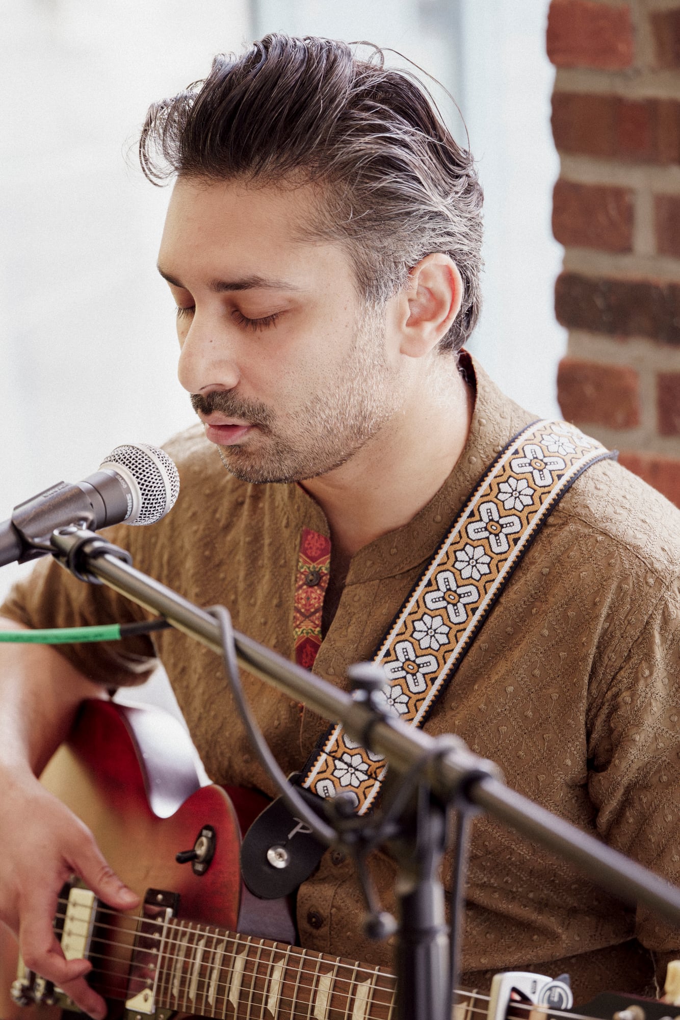 Umer Piracha singing with guitar